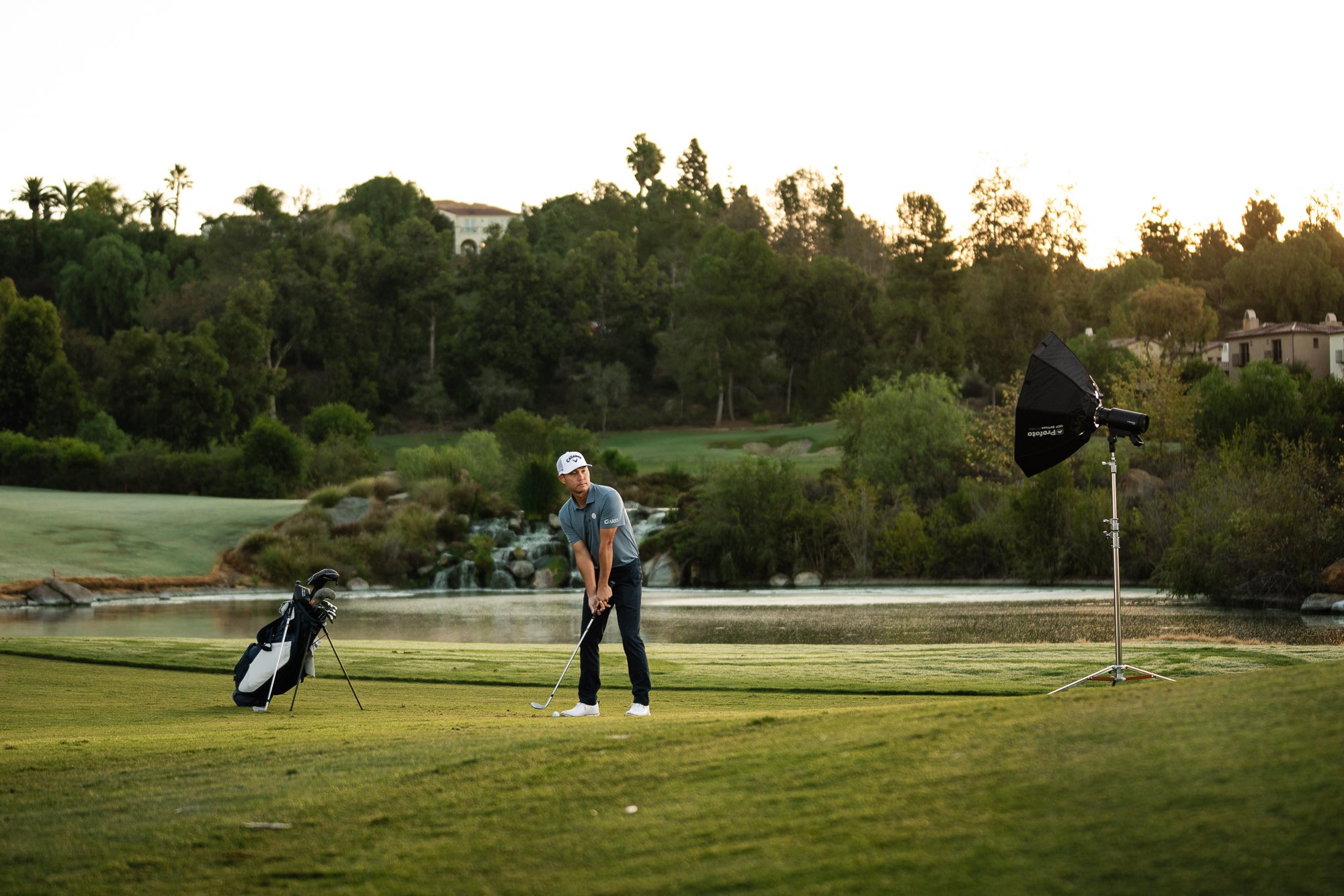 Behind the scenes: golfer at address with a Profoto head and softbox on the fairway